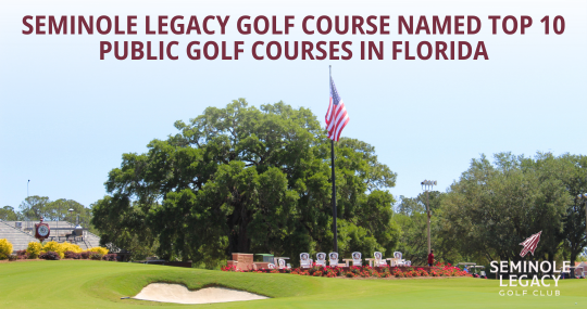 Promotional image of Seminole Legacy Golf Club at Florida State University. The foreground shows a manicured green with a sand bunker, colorful flower beds, and a flagpole flying the American flag. Large oak trees fill the background under a clear sky. Bold text at the top reads, ‘Seminole Legacy Golf Course Named Top 10 Public Golf Courses in Florida.’ The Seminole Legacy Golf Club logo appears in the bottom-right corner.